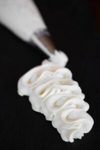 Mascarpone Cream Frosting is made with mascarpone, heavy cream, confectioners’ sugar, or any other powdered sugar sustitute like monkfruit, allulose, maple sugar, and almond and vanilla extracts is a lusciously smooth and creamy frosting. It is stable and holds its shape at room temperature and remains soft when refrigerated. It is a very delicate frosting, however, and works best as a cupcake topper as it will not provide structure to stacked cakes.